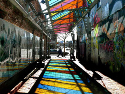 Alley with colorful glass ceilings reflecting on the ground
