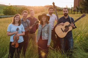 photo of Walking Roots Band smiling outside holding instruments