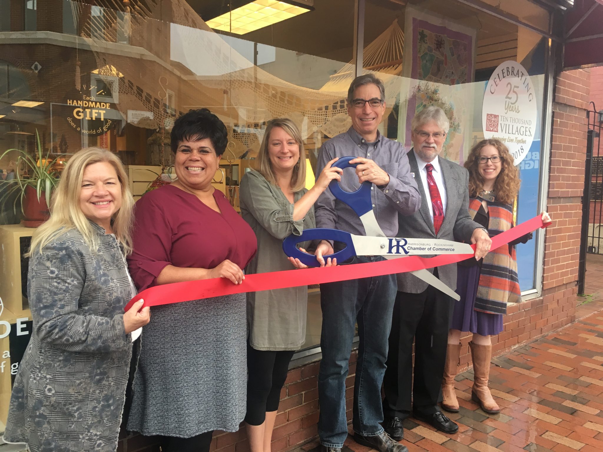 Happy people local business owners anniversary ribbon cutting