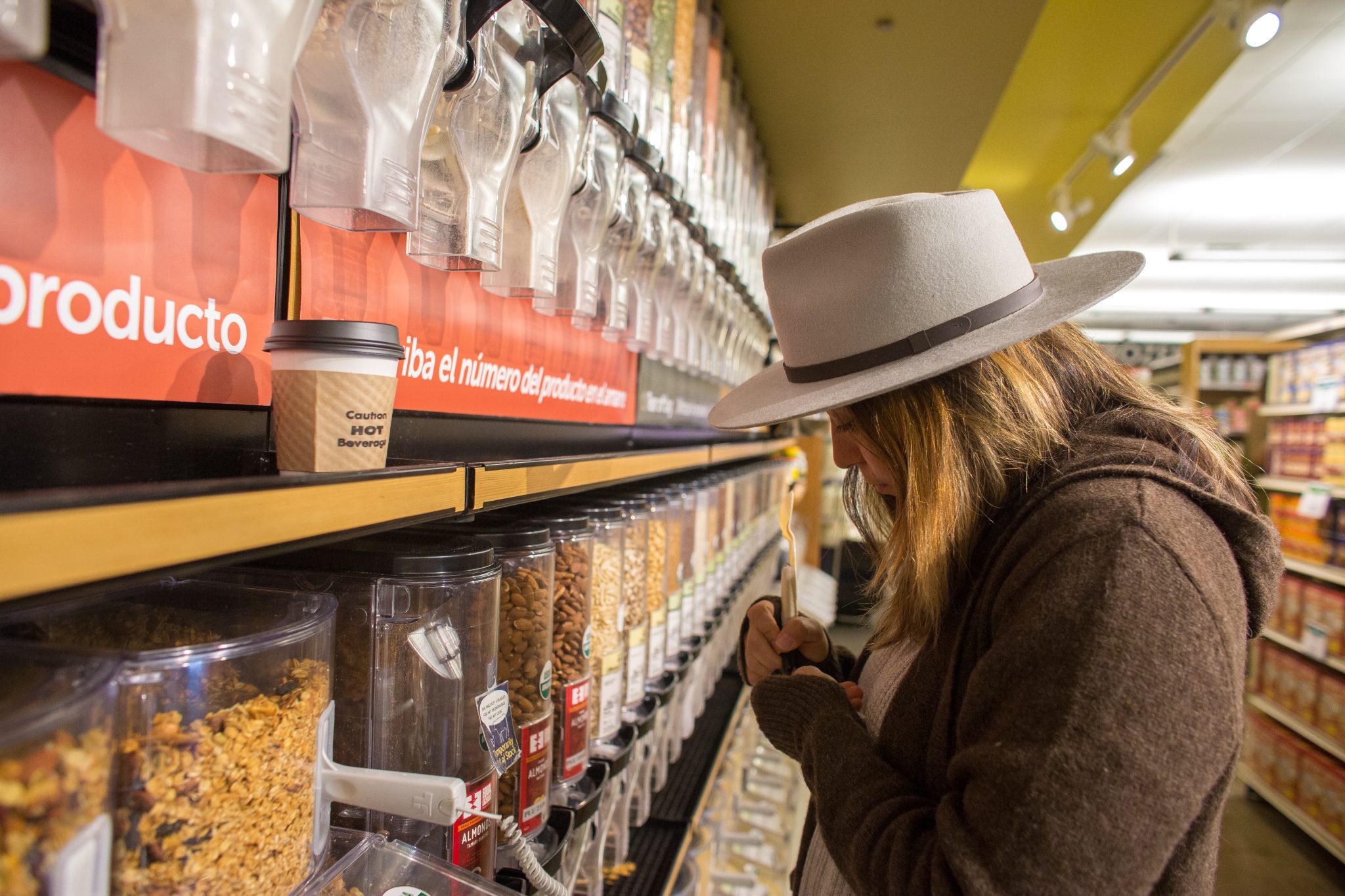 Woman white hat brown coat buying cereal at co-op
