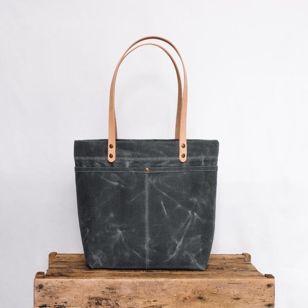 Dark grey purse on wooden bench