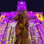 woman statue in front of building with disco lights