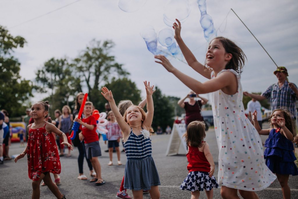 Happy children on Fourth of July playing with bubbles