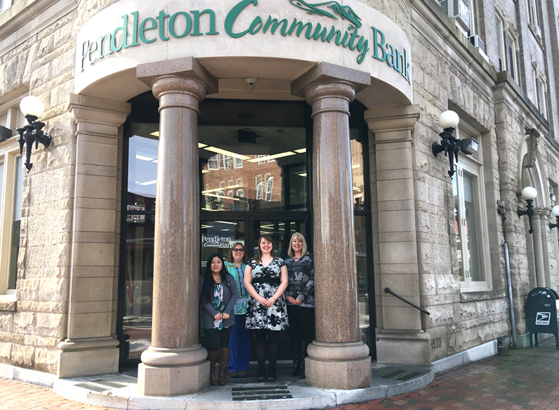 Happy women standing outside bank