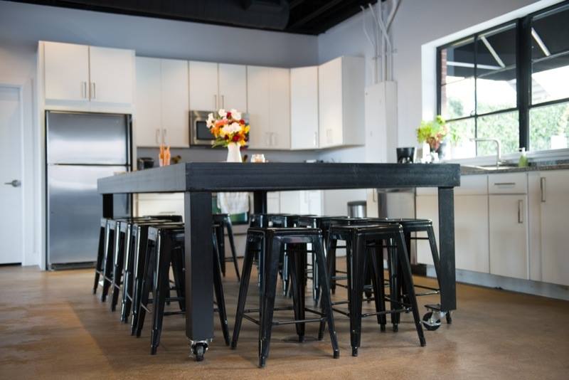 Kitchen with black table and white cabinets and wood flooring