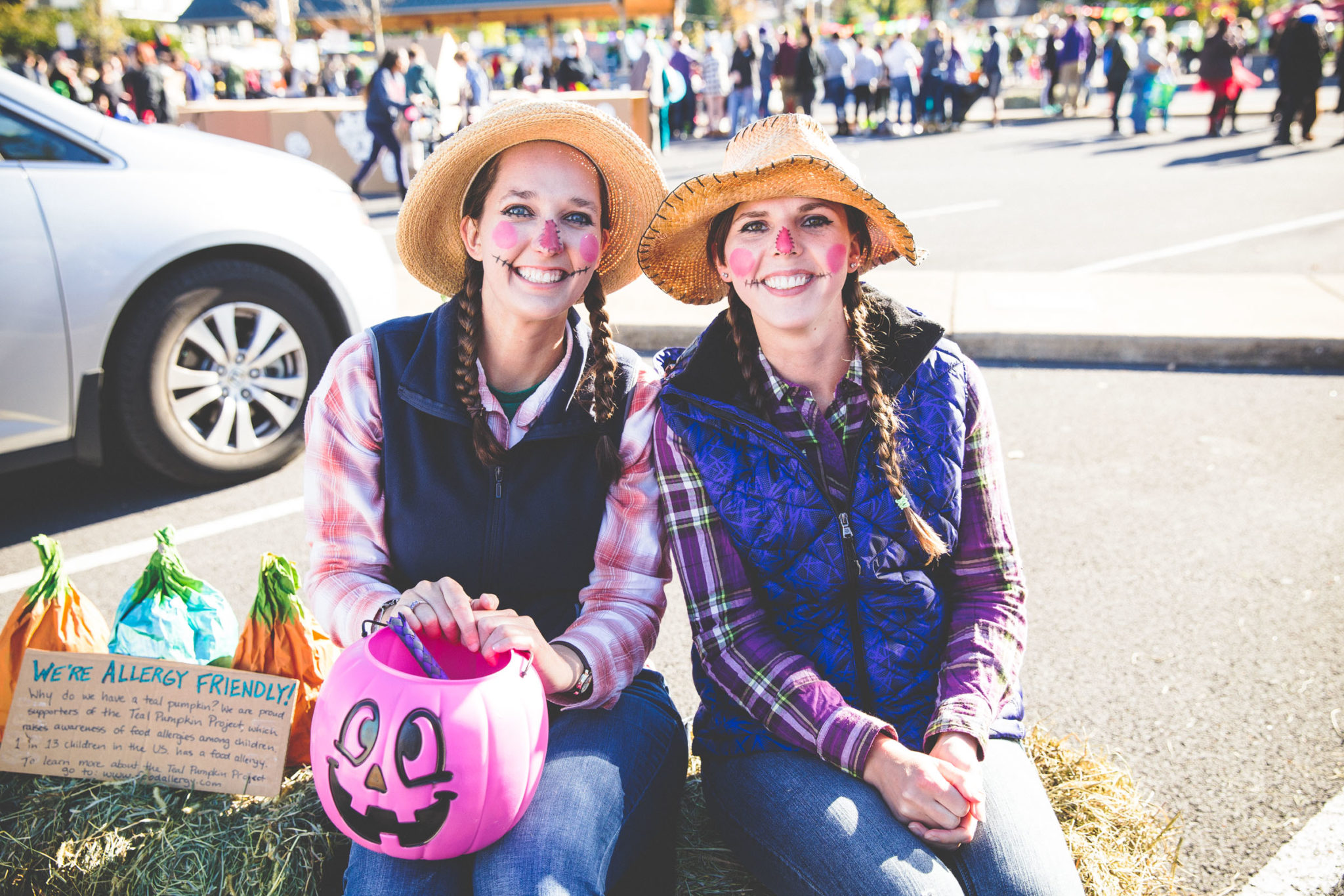 Smiling women dressed in scarecrow costumes at Halloween event downtown