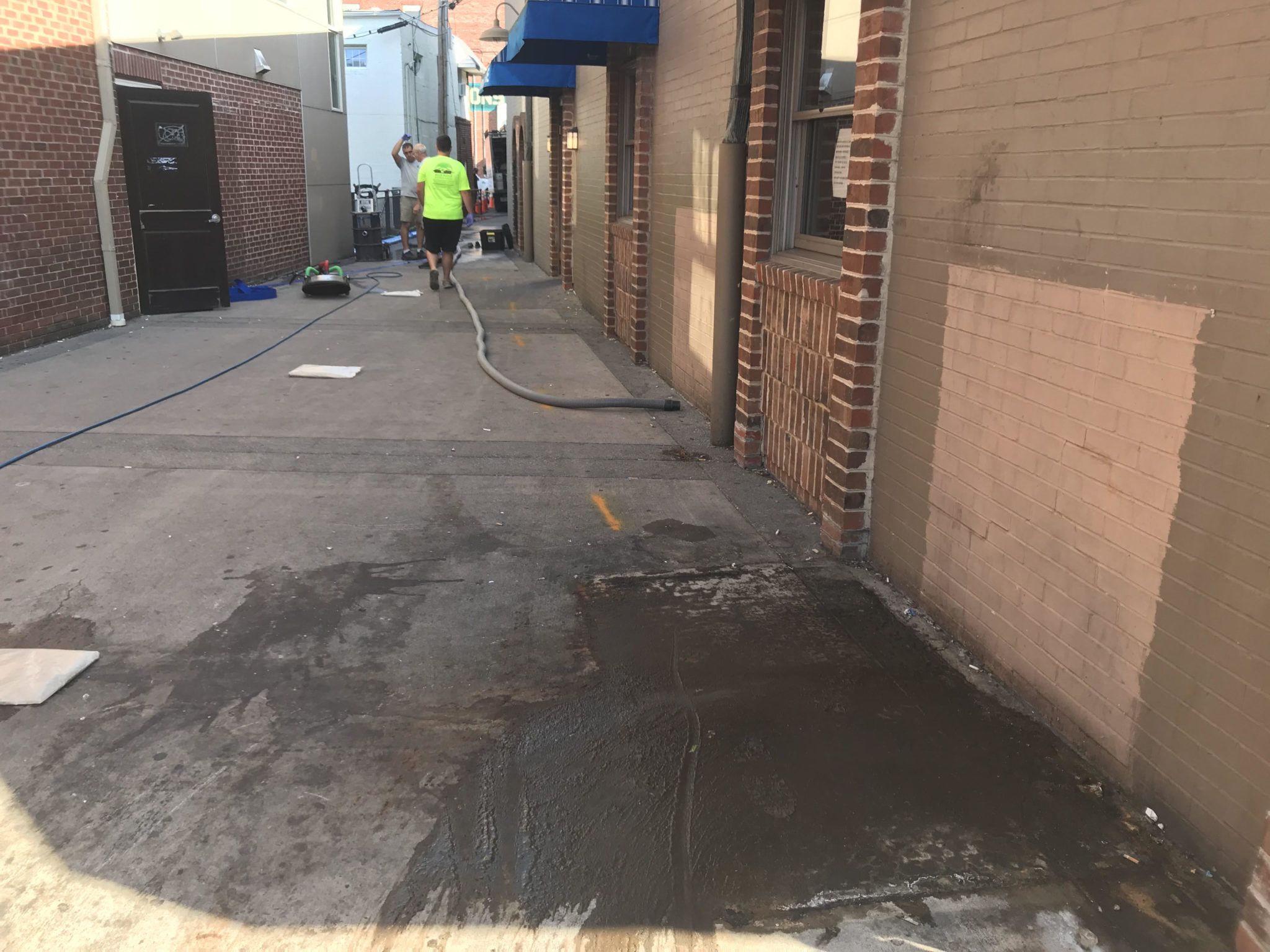 Men cleaning up an alleyway